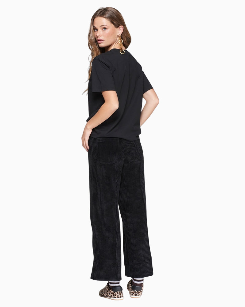 Back view of black corduroy trousers showing ribbed texture and clean finish