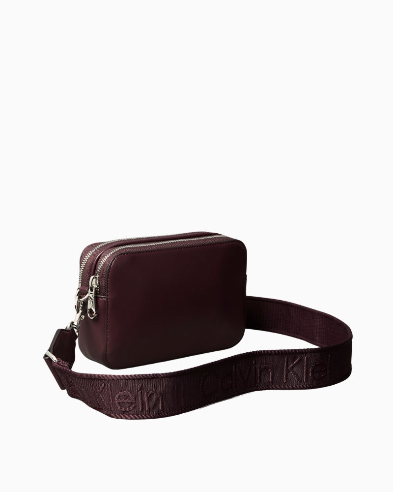 Back view of the Calvin Klein Webbing Double Strap Camera Bag in brown polyurethane with clean design.
