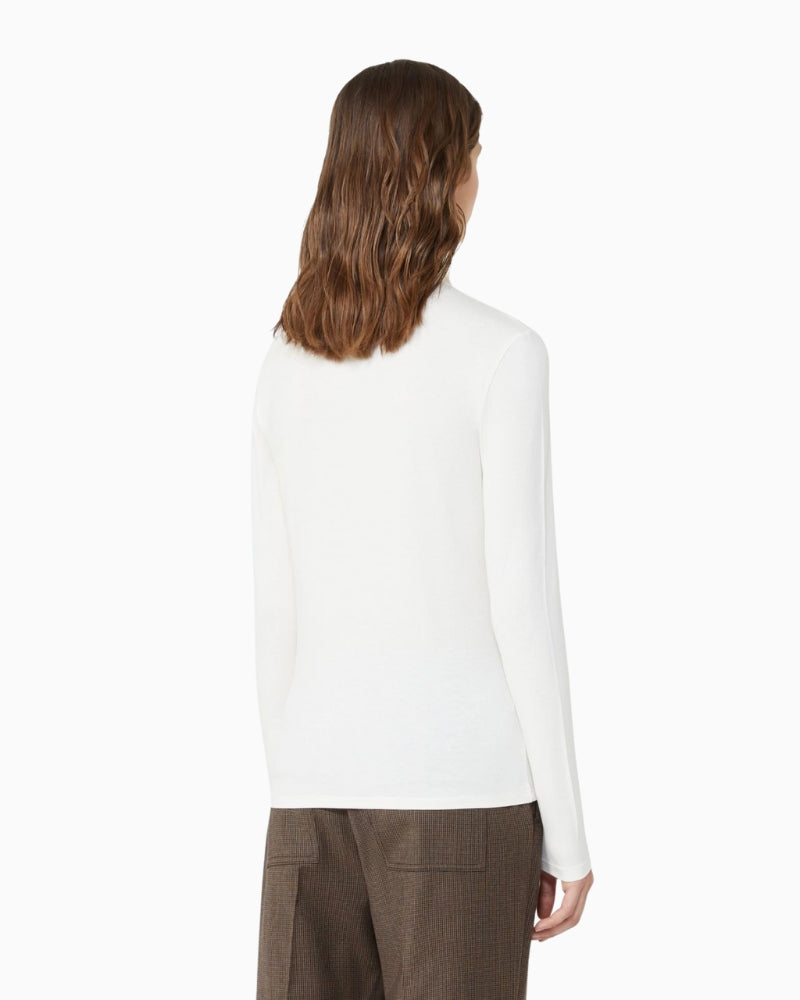 Back of cream fitted top showing butterfly logo at collar