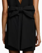 Back view of black mini blazer dress with V-cut and bow detail