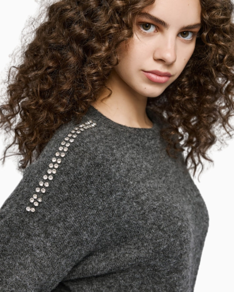 Close-up of round neckline and sparkle detailing on knit fabric