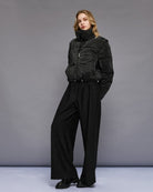 Model wearing black puffer jacket styled with jeans and boots