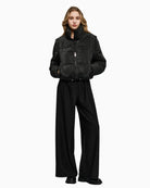 Model wearing black puffer jacket styled with jeans and boots