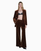 Model wearing trousers styled with matching blazer for a full velvet look