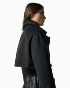 Side view of black belted quilted coat with long sleeves
