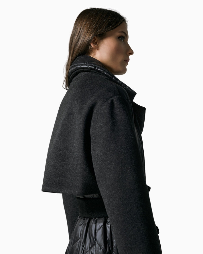 Side view of black belted quilted coat with long sleeves