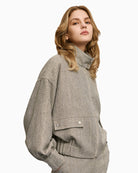 High neck grey jacket — side view showing elastic hem and sleeve detail