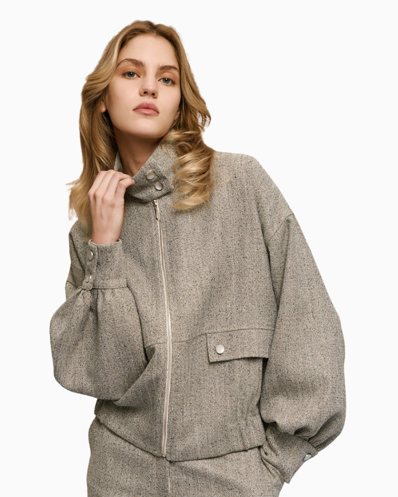 Front view of grey herringbone jacket with high neck, puff sleeves and flap pockets