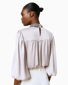 Back view of Silver Shimmery Blouse with button closure at neckline and smooth drape