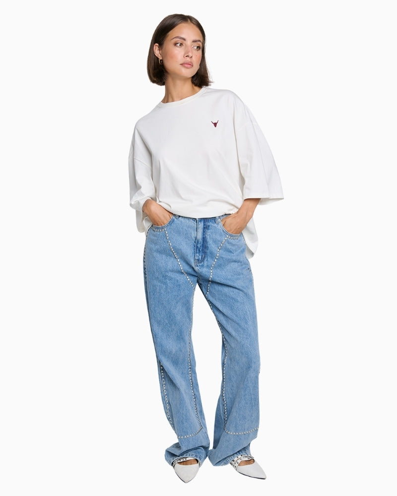 Full front view of relaxed straight‑leg denim blue pants with mid waist and studs
