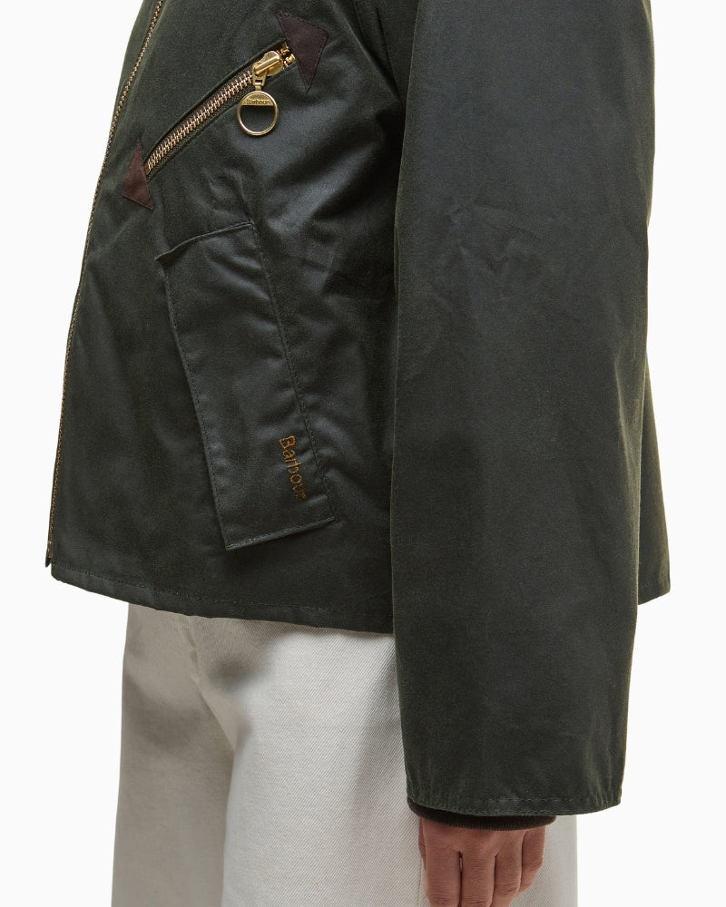 Side angle of olive Barbour waxed jacket highlighting the relaxed fit and extended cuffs