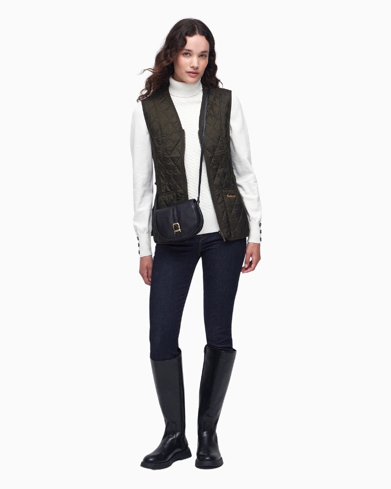 Model wearing olive quilted liner over knit jumper