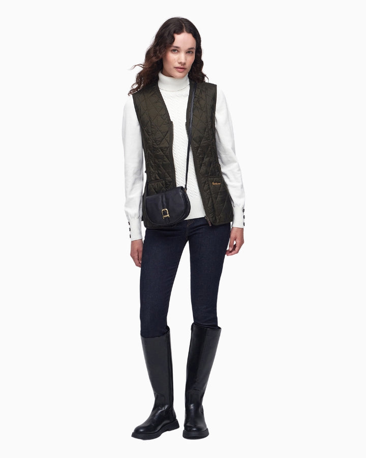 Model wearing olive quilted liner over knit jumper