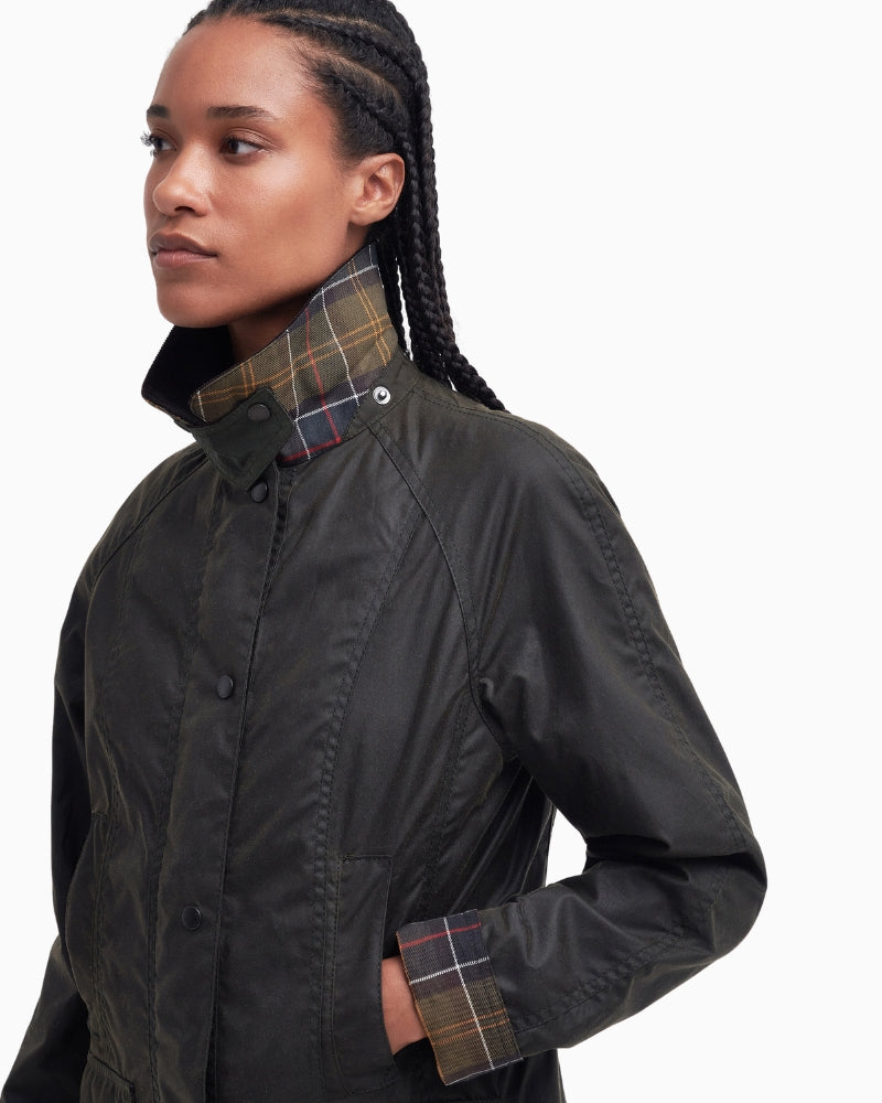 Styled look of olive Barbour Beadnell jacket with tartan lining peeking out