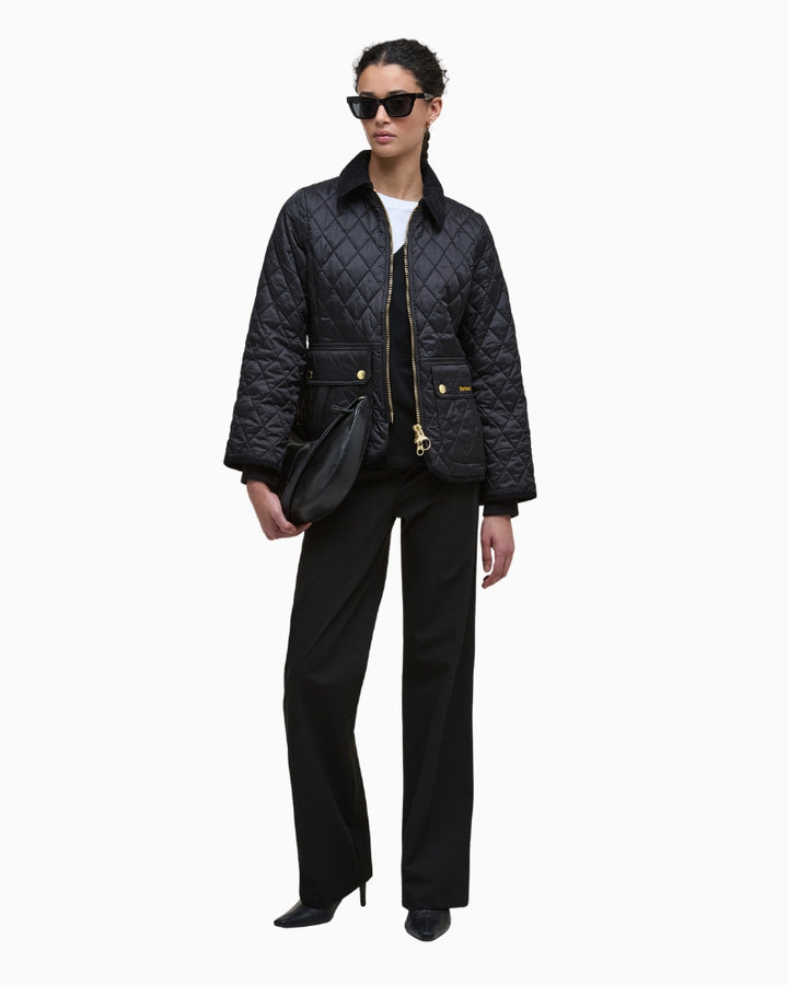 Styled outfit shot with quilted jacket layered over knit jumper and trousers