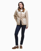 Model layering Barbour fleece over shirt with casual outfit