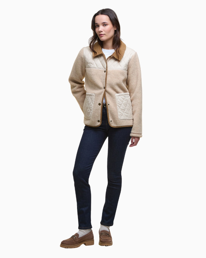 Model layering Barbour fleece over shirt with casual outfit