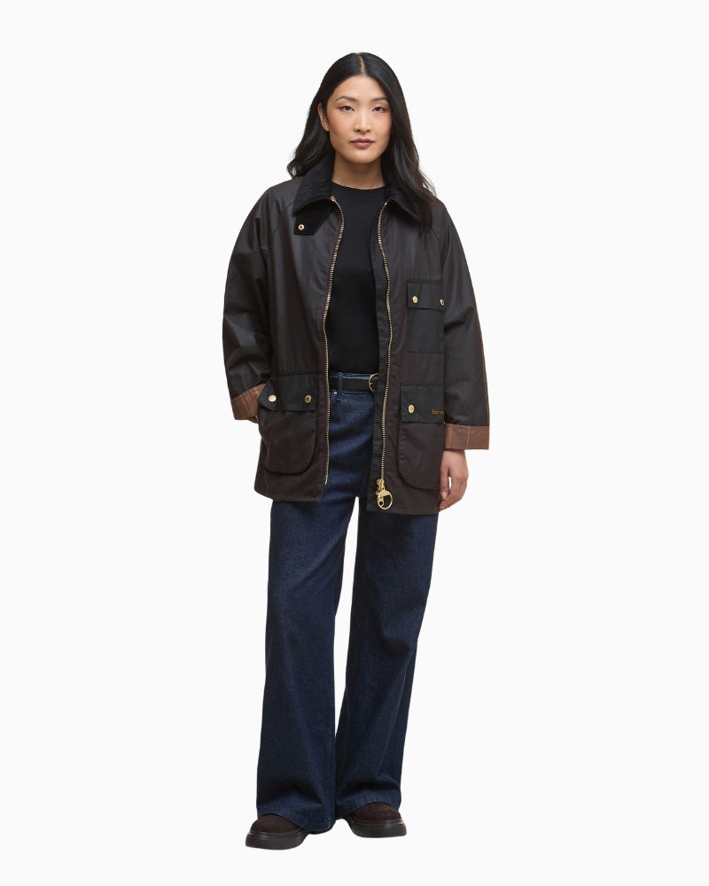 Model wearing black Barbour Luella over knit and jeans