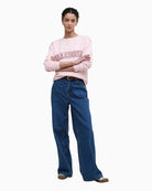 Model wearing pink Barbour sweatshirt with jeans