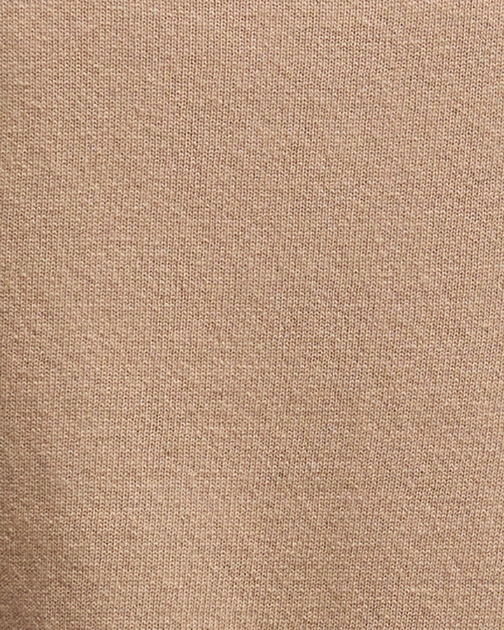 Zoomed-in view of fabric showing fine knit detail and soft camel colouring