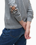 Detailed view of ribbed hem and sleeve cuff on grey wool-cotton Barbour knit