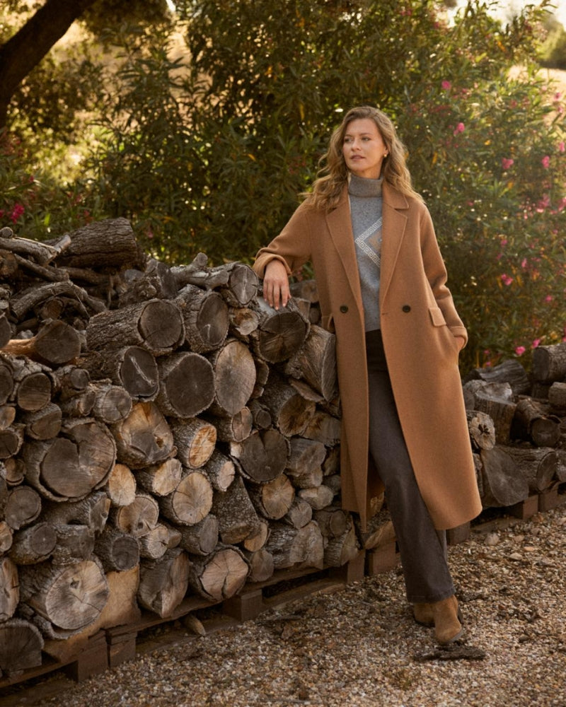 Model wearing Bariloche camel coat over knit and jeans