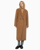 Model wearing Bariloche camel coat over knit and jeans