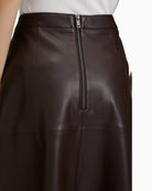 Close-up of pocket detail and leather-like texture on midi skirt