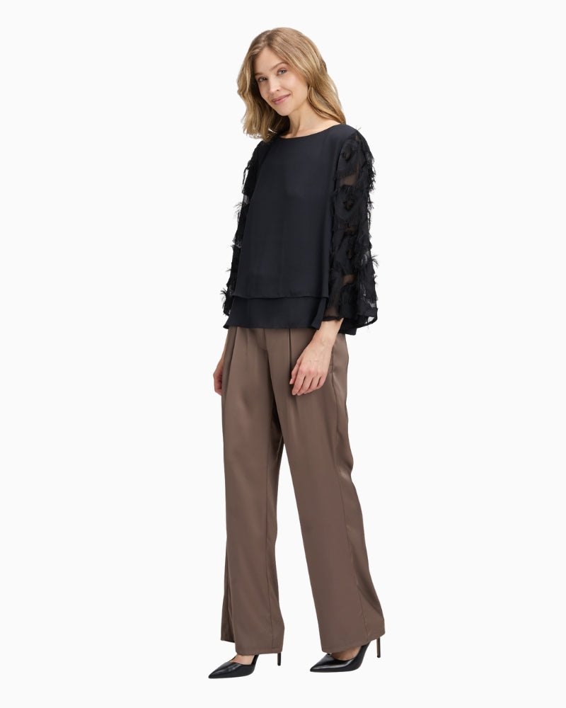 Model wearing blouse tucked into trousers for a smart-casual look