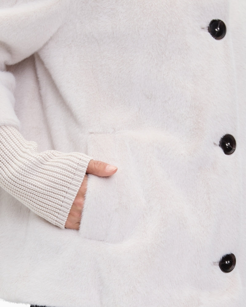 Close-up of piped pocket and plush fabric on women’s short jacket