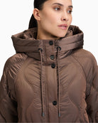 Close up of Long quilted jacket by Betty Barclay with hood and piped pockets