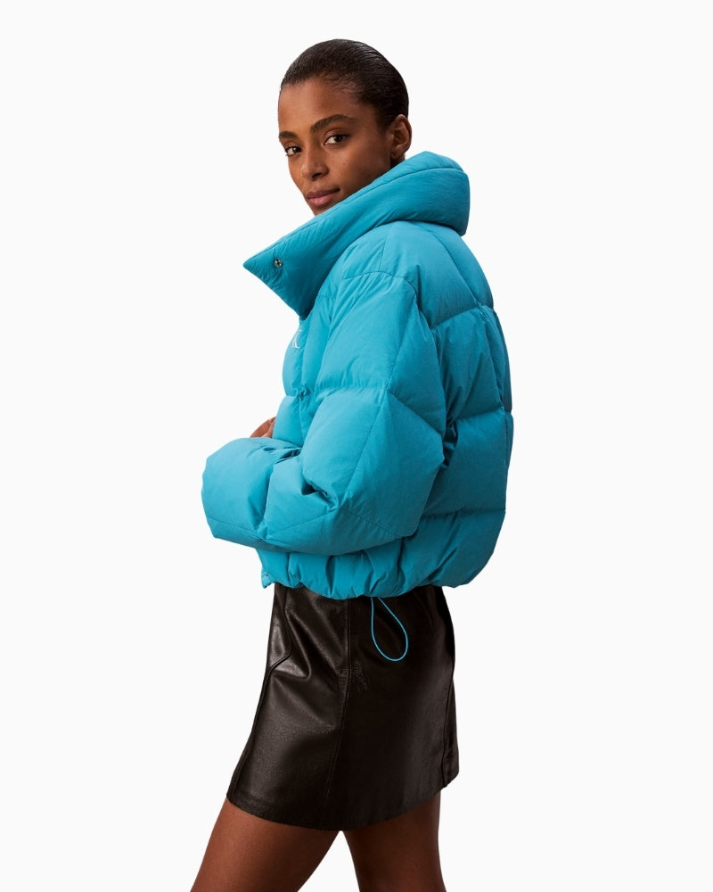 Side profile of short teal down puffer by CK Jeans