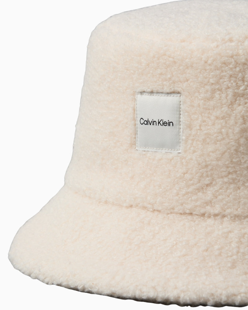 Close-up of logo patch detail on Calvin Klein bouclé bucket hat