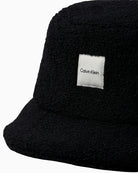 Close-up of Calvin Klein logo patch on textured black hat