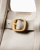 Close-up of buckle detail and textured stitching on Calvin Klein taupe bag