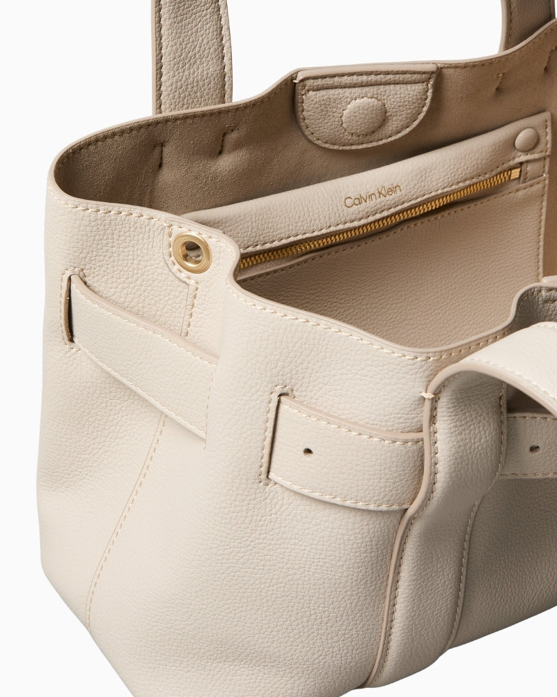 Close-up of buckle detail and textured stitching on Calvin Klein taupe bag
