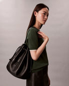 Model view Calvin Klein embossed bucket bag with drawstring closure