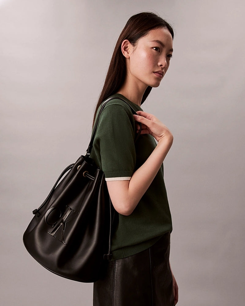 Model view Calvin Klein embossed bucket bag with drawstring closure