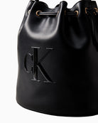 Close-up of tonal embossed Calvin Klein logo on bucket bag