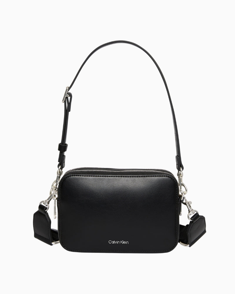 Front view of Calvin Klein taupe pocket bag with webbing straps and structured shape