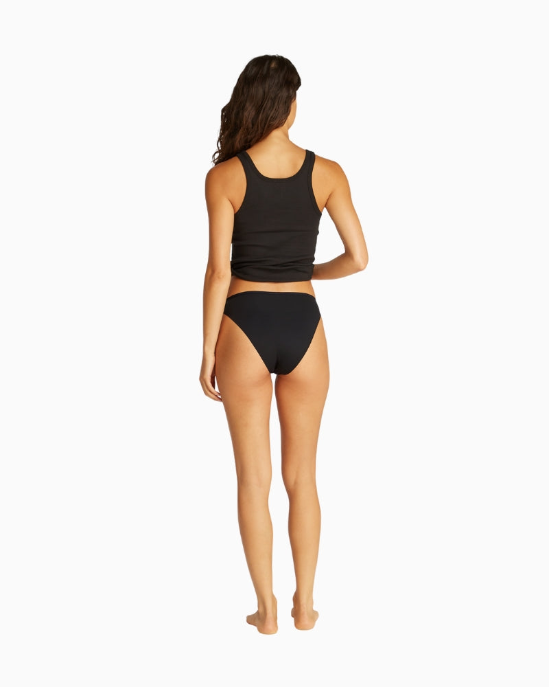 Back view of model wearing black bikini briefs showing full coverage