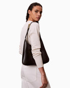 Woman wearing Calvin Klein engraved medium shoulder bag black shoulder fit – Áines Boutique