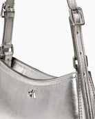 Calvin Klein metallic small shoulder bag in silver, close-up detail of texture and branding – Áines Boutique