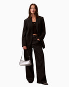 Woman wearing Calvin Klein metallic small shoulder bag in silver, styled on shoulder – Áines Boutique