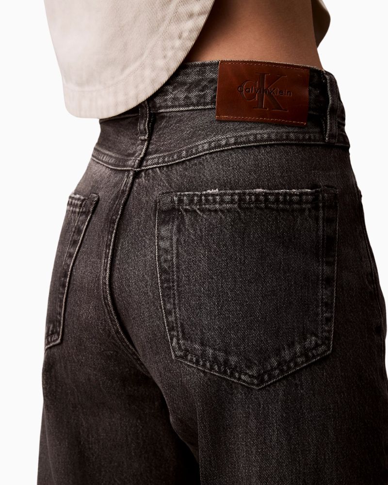 Close-up of rigid denim texture and branded hardware