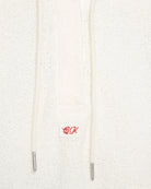 Close-up of Calvin Klein logo embroidery on white hoodie with soft textured finish
