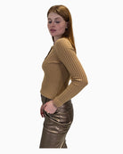 Side profile of a woman wearing the beige Eva Kayan ribbed jumper, showing its fitted shape.