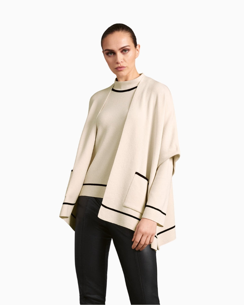 Front view of Faber open cape in natural knit with black contrast edging