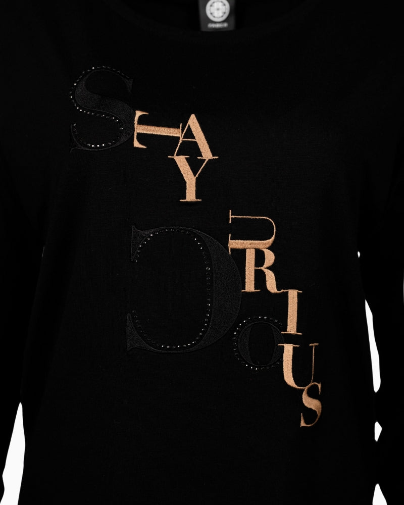 Close-up of embroidered lettering and decorative stones on Faber black top