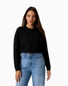 Black cropped cable knit sweater by Guess with rounded neckline